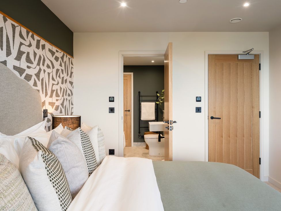 A bedroom with a bed and an adjoining bathroom at tbc in St. Ives