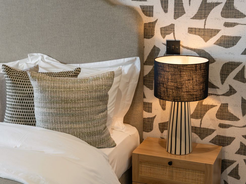 A bedroom with pillows and a lamp on a nightstand at tbc in St. Ives