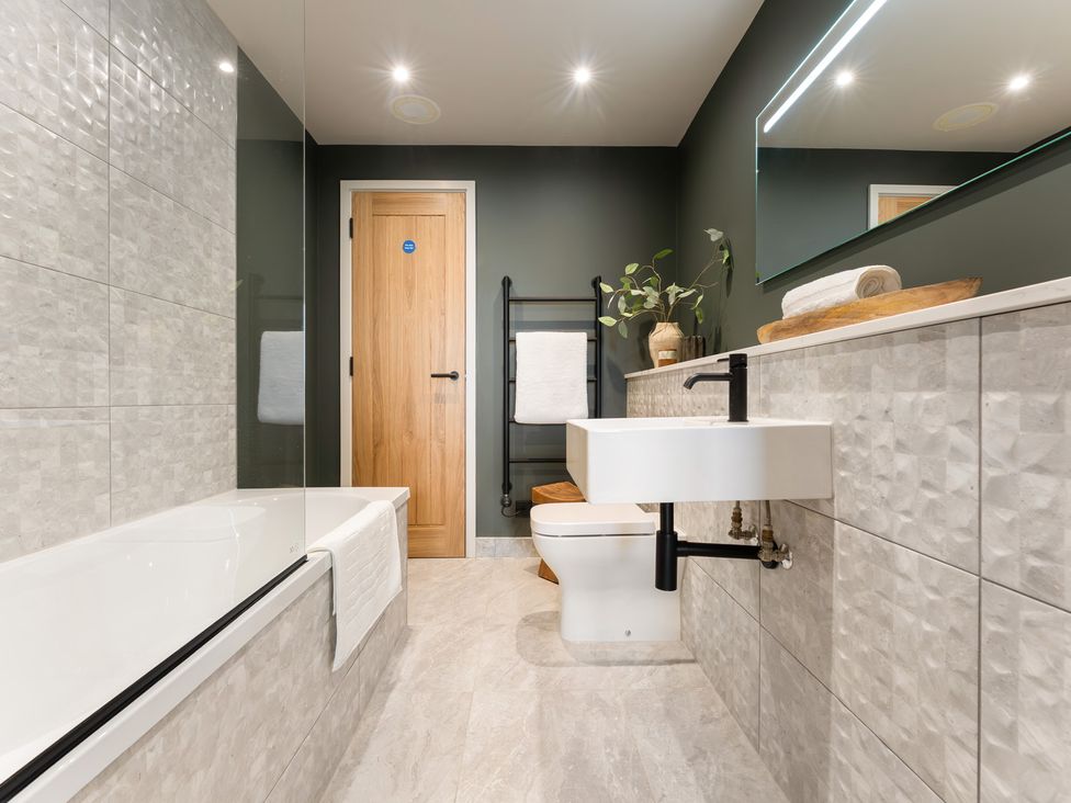 A bathroom with a bathtub, toilet, and sink at tbc in St. Ives