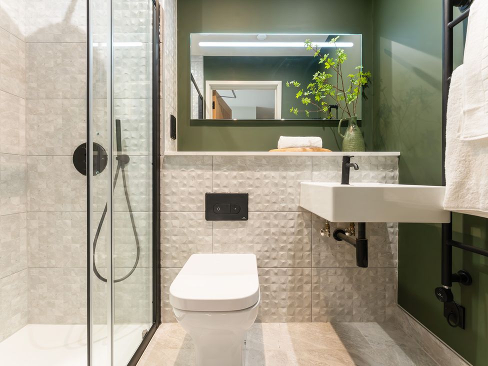 A bathroom with a shower, toilet, and sink at tbc in St. Ives