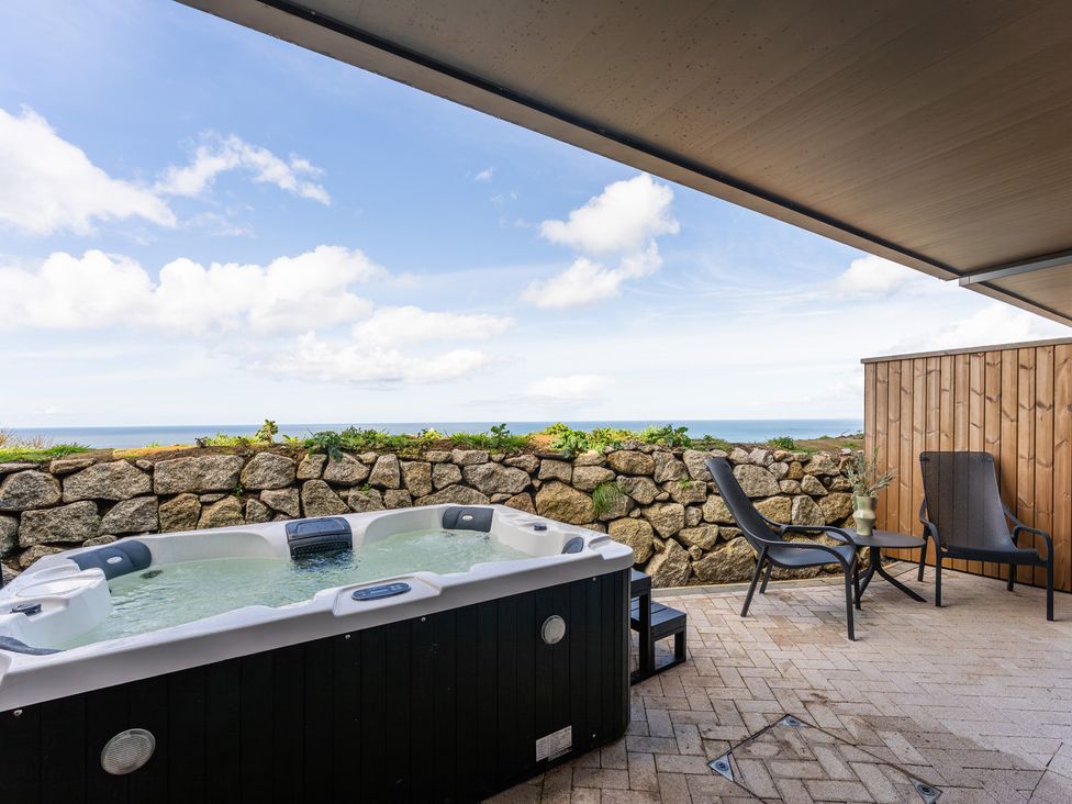 An outdoor area with a hot tub and chairs at tbc in St. Ives