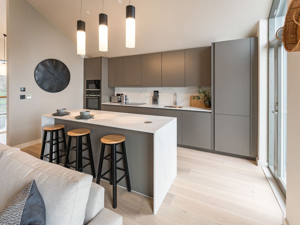 A kitchen with a central island and stools at tbc in St. Ives