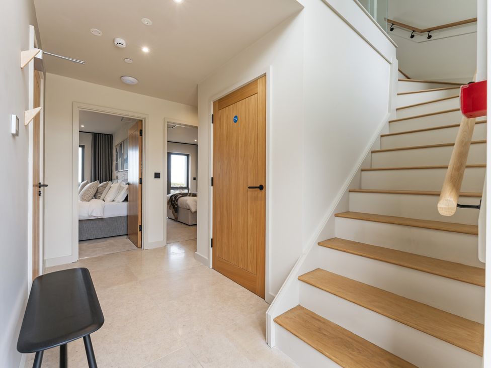 A hallway with stairs and a door at tbc St. Ives
