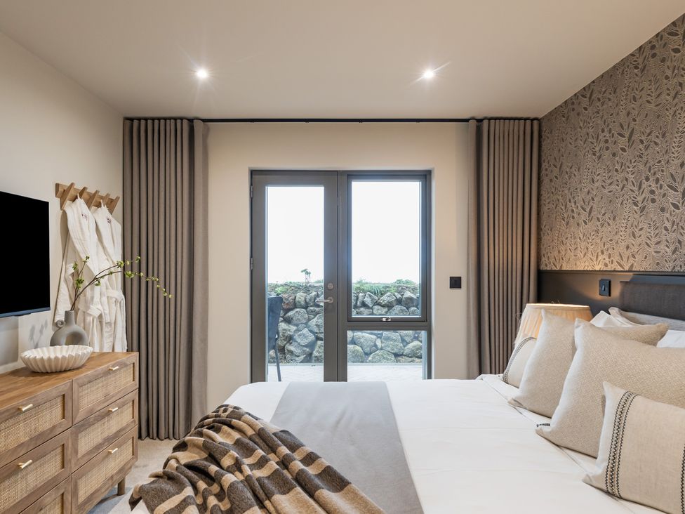 A bedroom with a bed and dresser at tbc in St. Ives