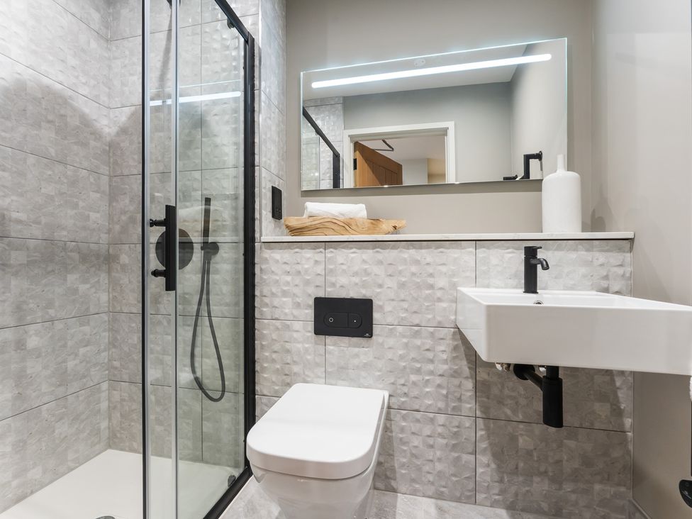 A bathroom with a glass shower, toilet, and sink at tbc in St. Ives