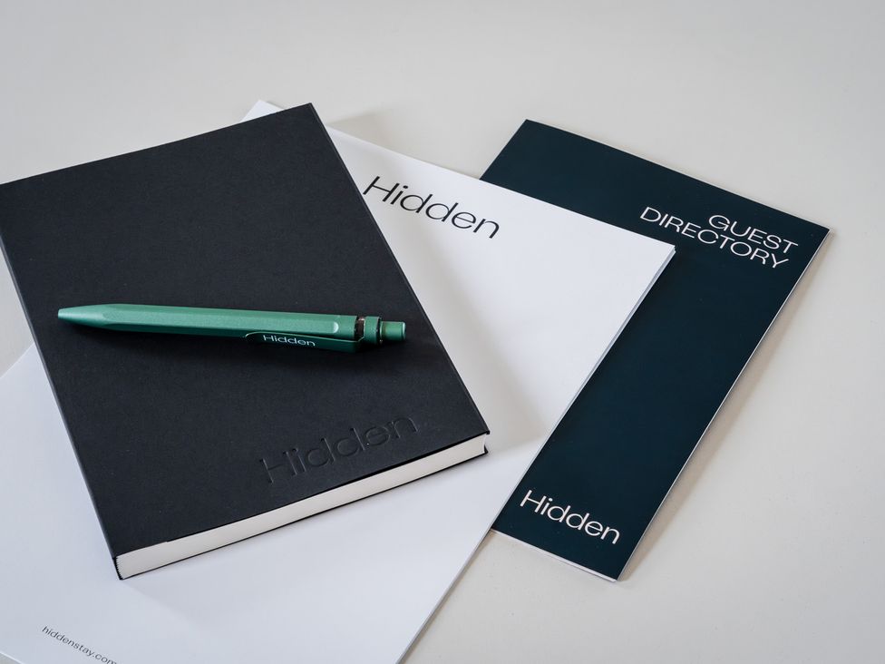 A notebook, pen, and guest directory on a table at Hidden 3- Sea Terrace House in St Ives