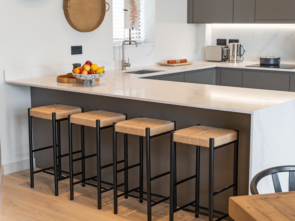 A kitchen with bar stools and a fruit bowl at tbc in St. Ives