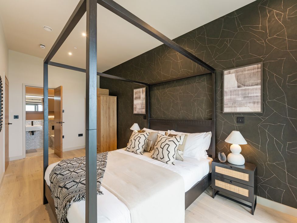 A bedroom with a four-poster bed and bedside table at tbc in St. Ives