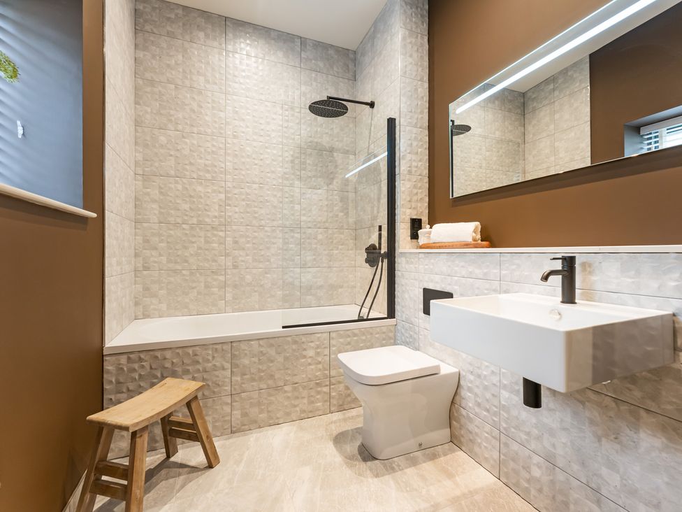 A bathroom with a bath tub, shower, toilet, and sink at tbc in St. Ives