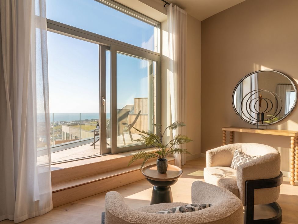 A living room with a window and chairs at Hidden 9 – Grand Bay Suite Hot Tub St Ive