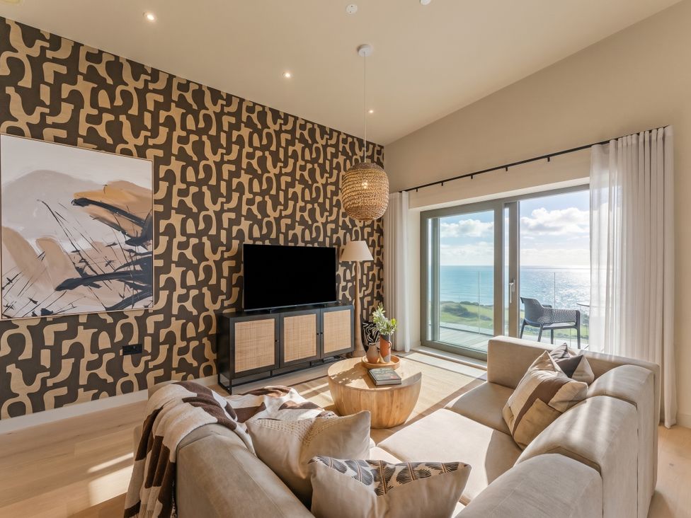 A living room with a sofa and television at Hidden 9 – Grand Bay Suite Hot Tub, St Ive