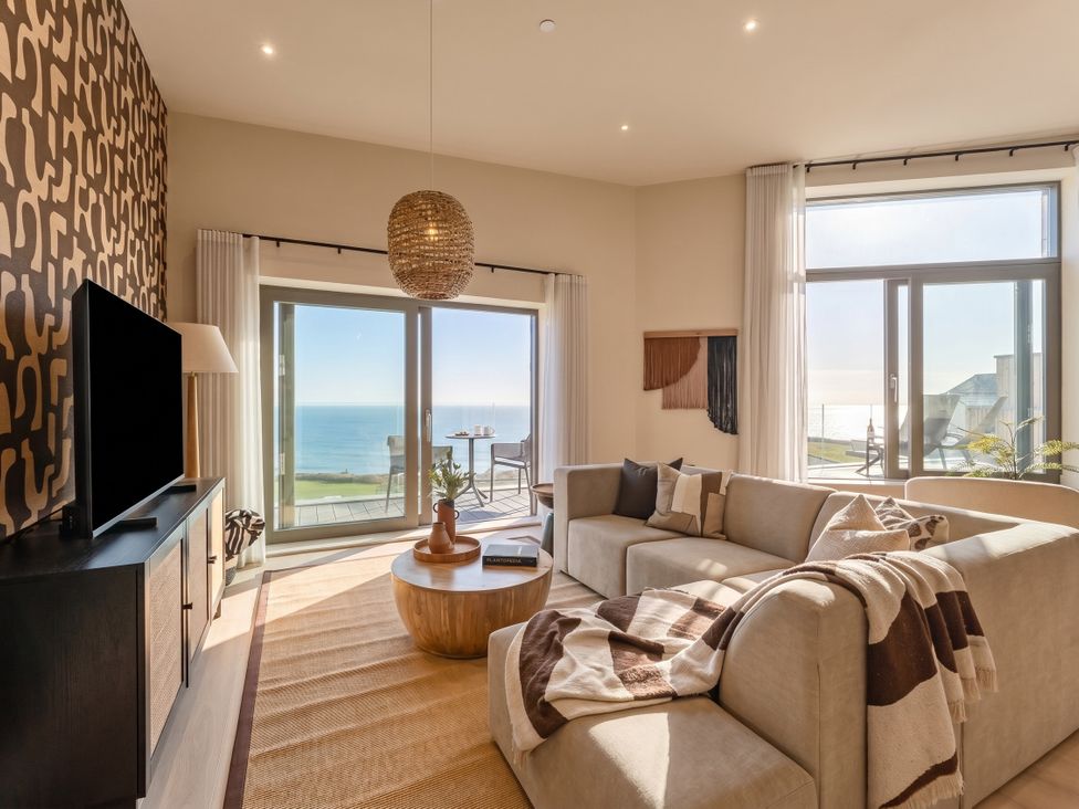 A living room with a sofa and coffee table at Hidden 9 – Grand Bay Suite Hot Tub in St Ive