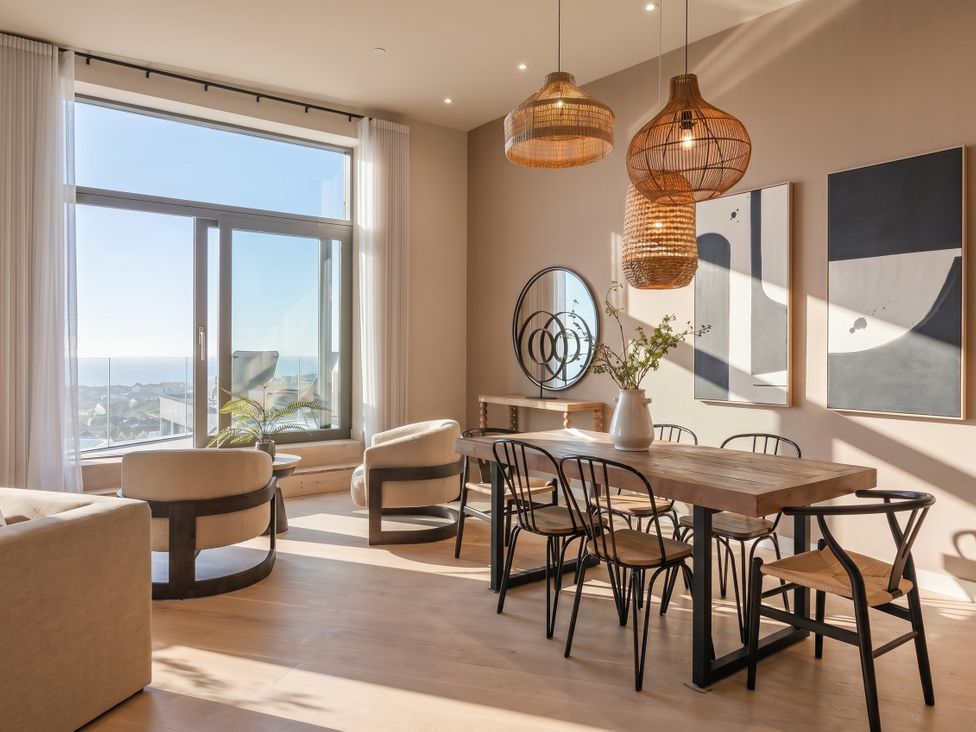 A dining room with a table and chairs at Hidden 9 – Grand Bay Suite Hot Tub St Ive