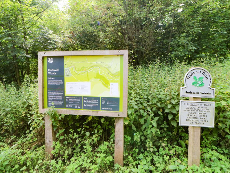 An information sign and notice board in Hudswell Woods