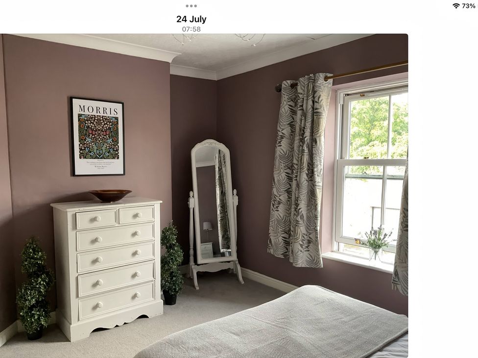 A bedroom with a mirror and chest of drawers at 2 West View Richmond