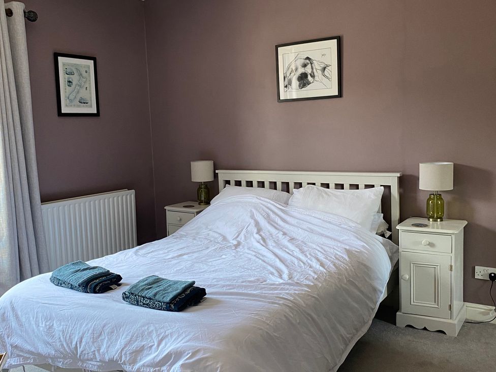 A bedroom with a bed, nightstand, and lamp at 2 West View in Richmond