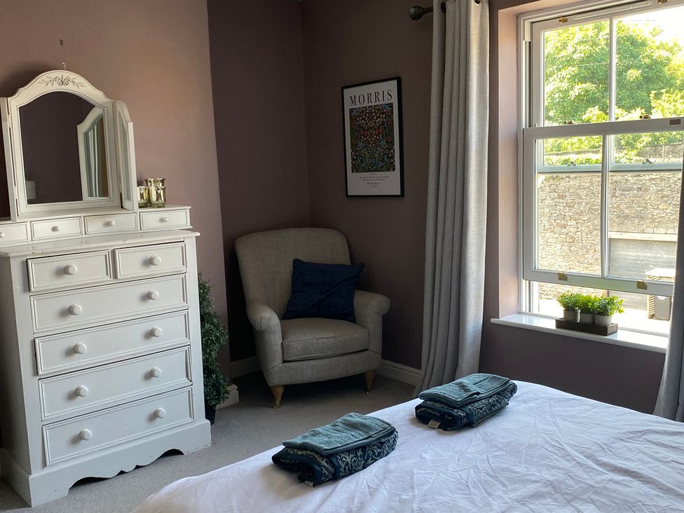 A bedroom with a dresser and armchair at 2 West View in Richmond