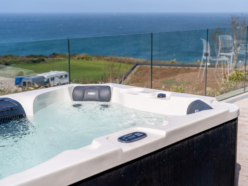 A hot tub with water and a sea view at tbc St. Ives
