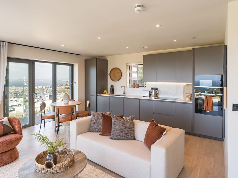 A living room with a kitchen area and dining table at tbc in St. Ives