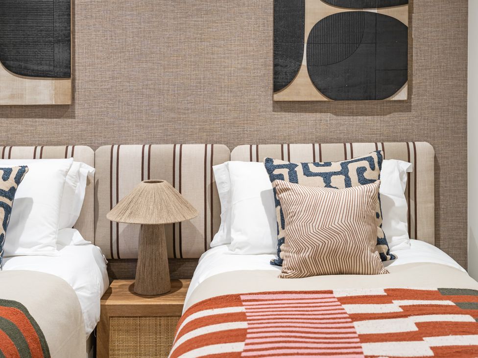 A bedroom with two beds and decorative pillows at tbc in St. Ives