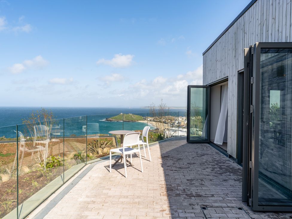 An outdoor area with a table and chair overlooking the sea at tbc St. Ives