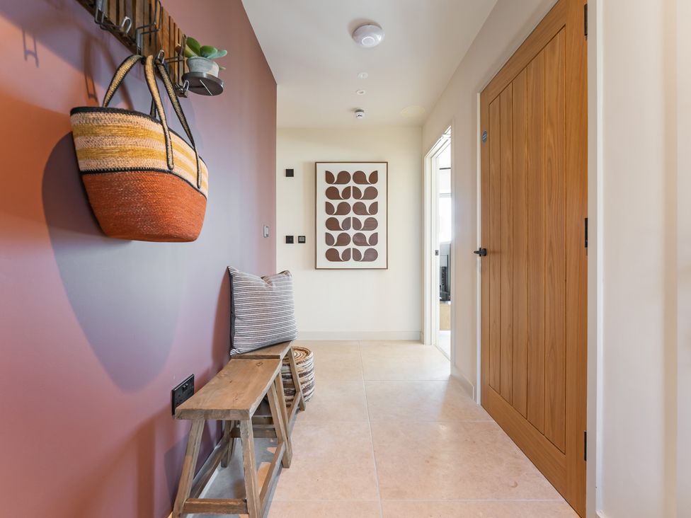 A hallway with a bench and wall art at tbc in St. Ives