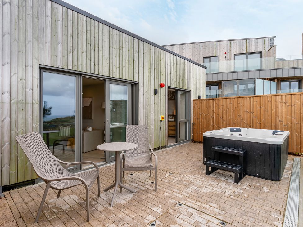 A patio with a hot tub and seating area at tbc in St. Ives
