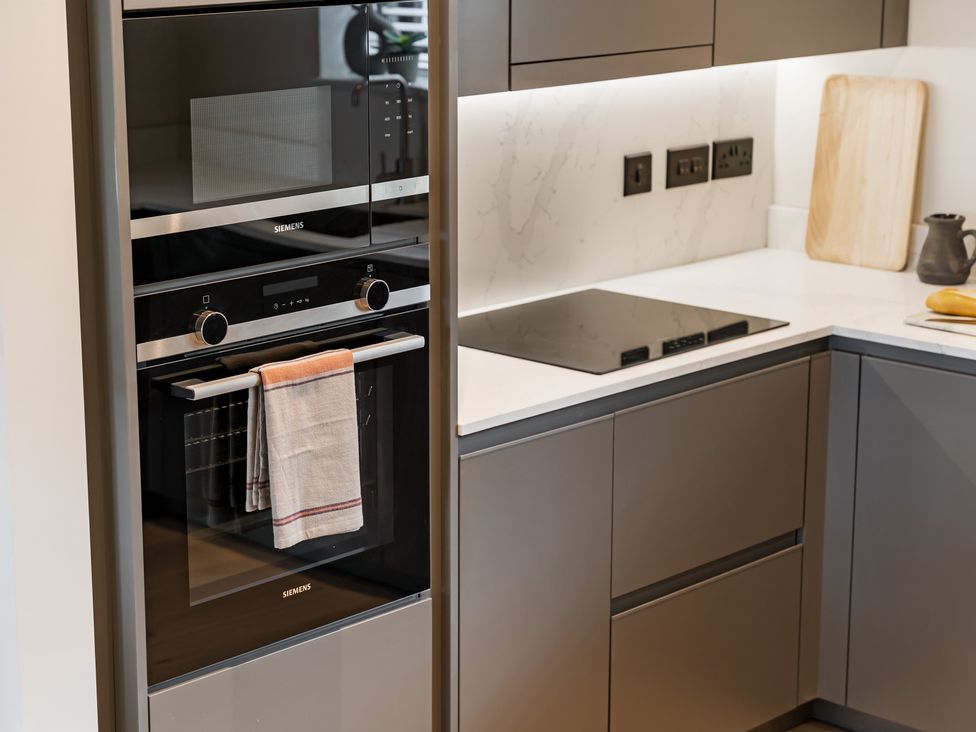 A kitchen with built-in oven and microwave at The Old Barn in St. Ives