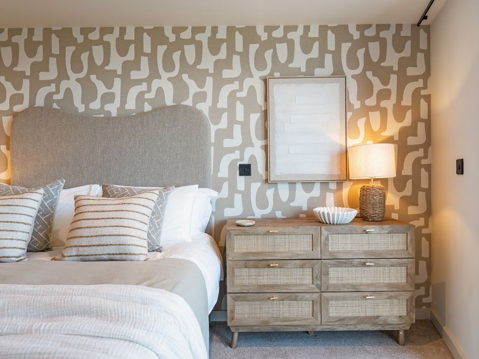 A bedroom with a bed and dresser at tbc in St. Ives