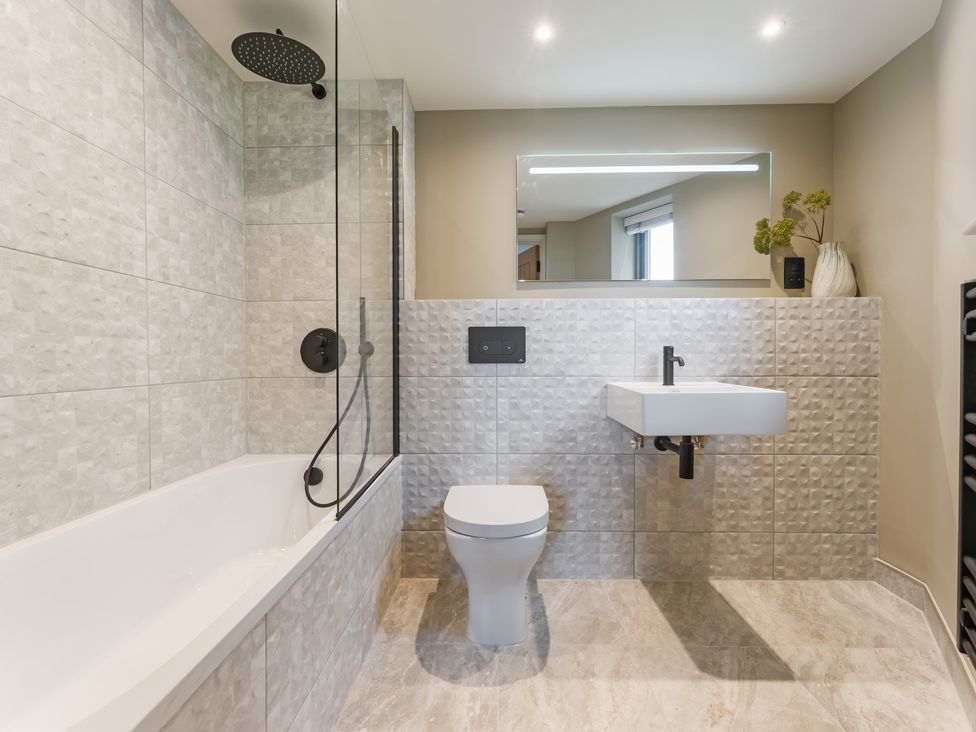 A bathroom with a bathtub, sink, and toilet at tbc in St. Ives