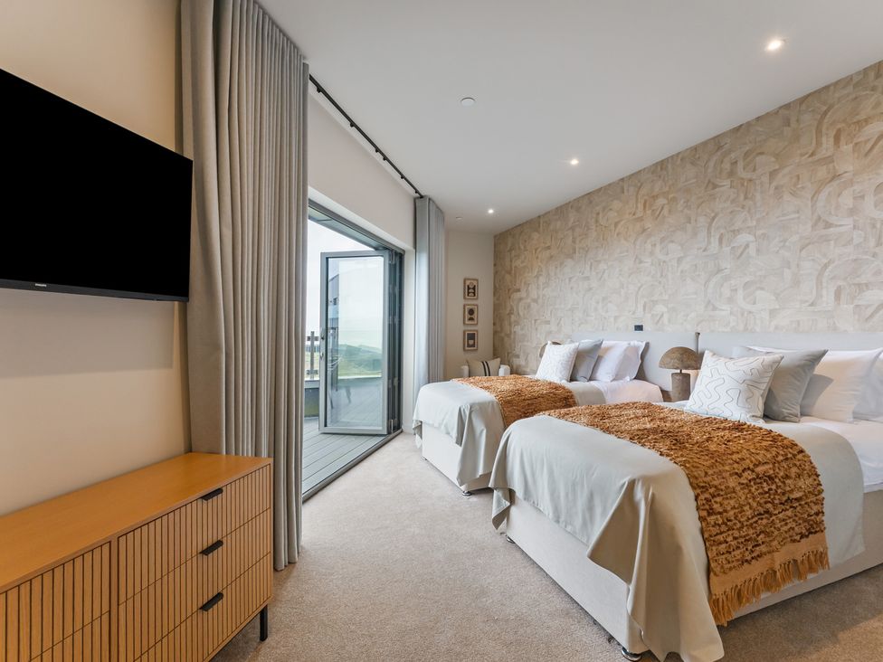 A bedroom with two beds and a television at tbc in St. Ives