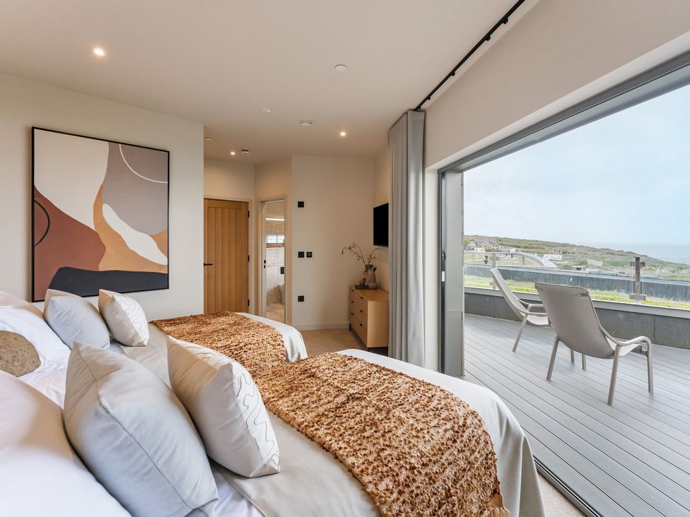 A bedroom with two beds and a sliding door at tbc in St. Ives
