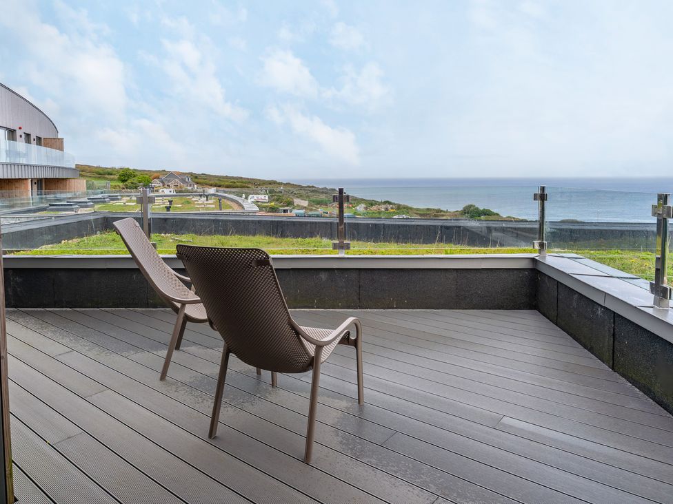An outdoor area with chairs and a view at The Old Barn in St. Ives