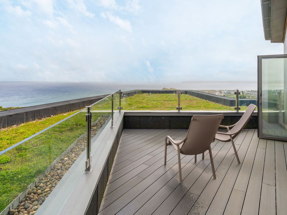 A deck with chairs and ocean view at tbc in St. Ives
