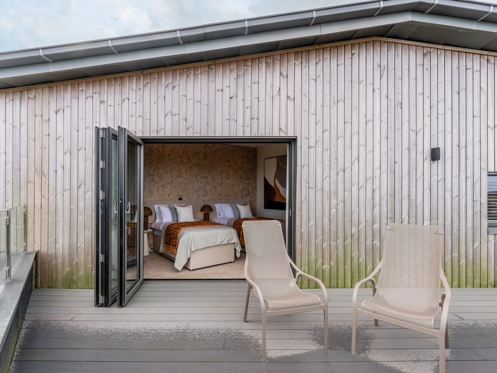 A patio with two chairs and an open door leading to a bedroom at tbc St. Ives