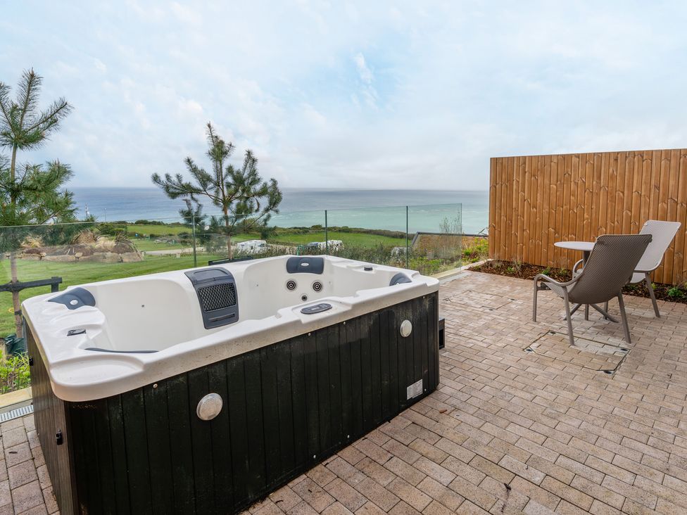 An outdoor area with a hot tub and chair at tbc in St. Ives