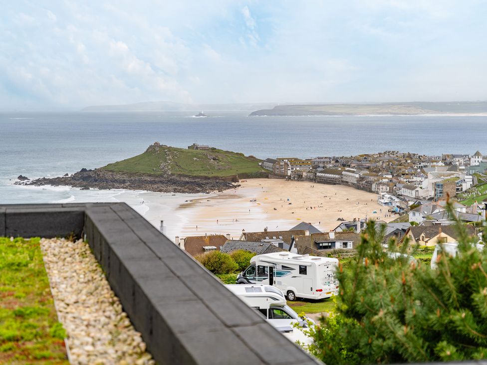 A beach with houses and a campervan at tbc in St. Ives