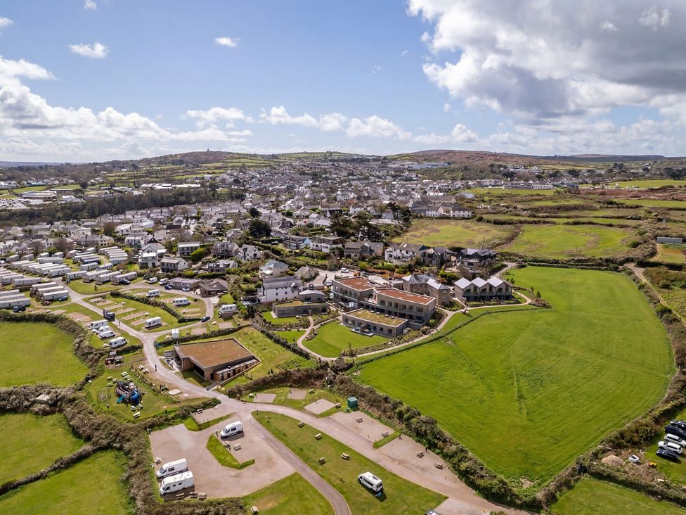 An aerial view of a town with fields and caravans at tbc in St. Ives