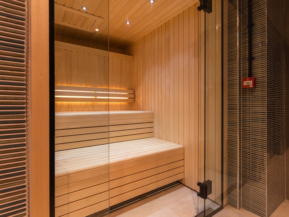 A sauna with wooden benches and a glass door at Hidden 17- Lookout Terrace Hot Tub St Ives