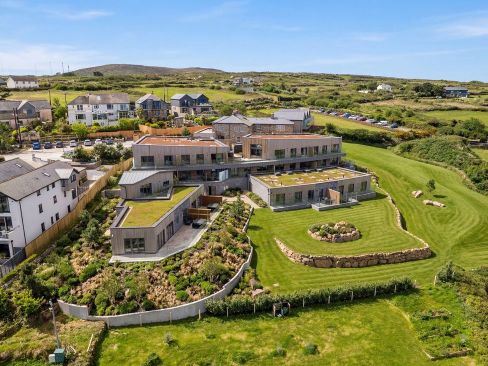 An exterior view of a modern building with gardens at Hidden 17- Lookout Terrace Hot Tub in St Ives