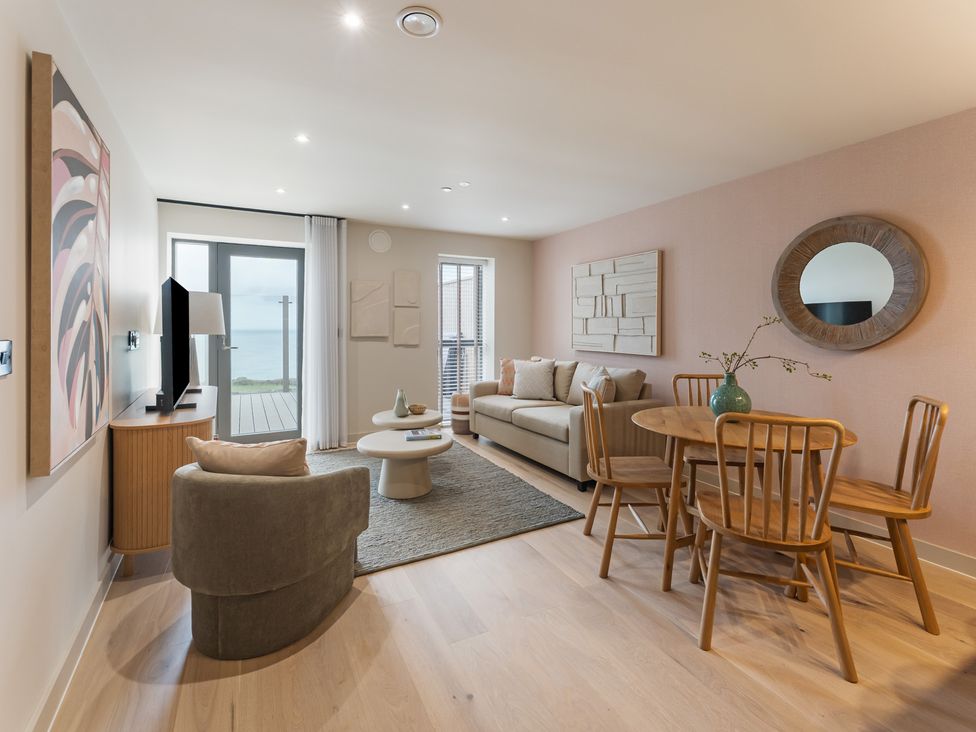 A living room with a sofa and dining table at tbc in St. Ives