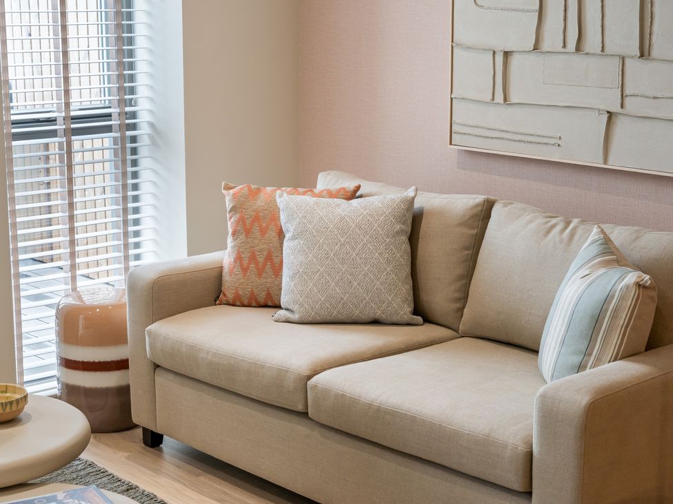 A living room with a sofa and cushions at tbc St. Ives