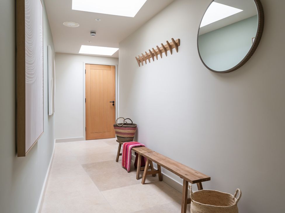 A hallway with a bench, mirror and coat rack at tbc in St. Ives