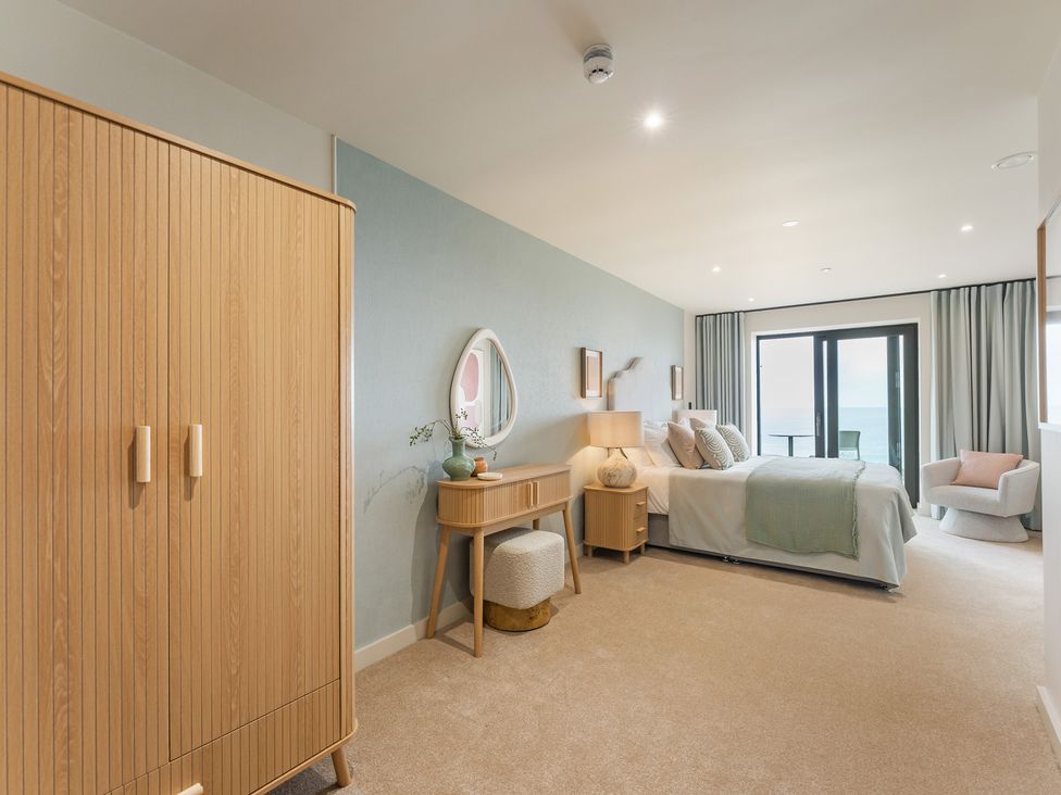 A bedroom with a bed and wardrobe at tbc in St. Ives