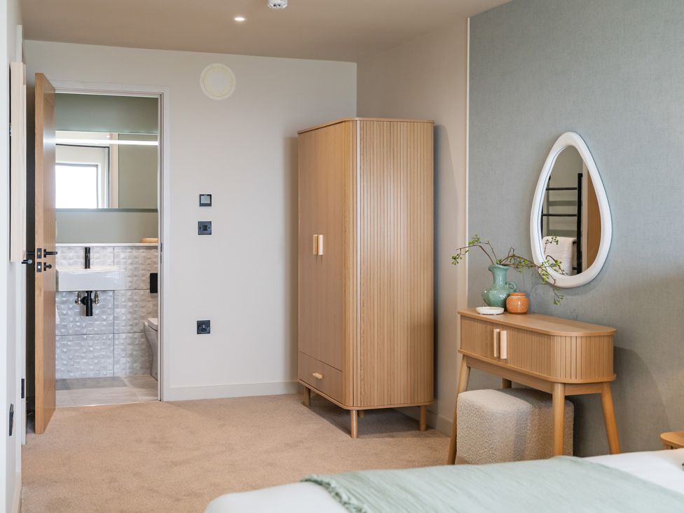 A bedroom with a wardrobe and vanity at tbc in St. Ives