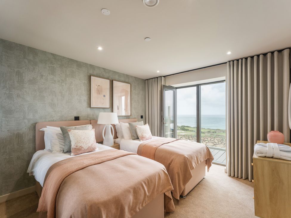 A bedroom with two beds and a view of the sea at tbc in St. Ives