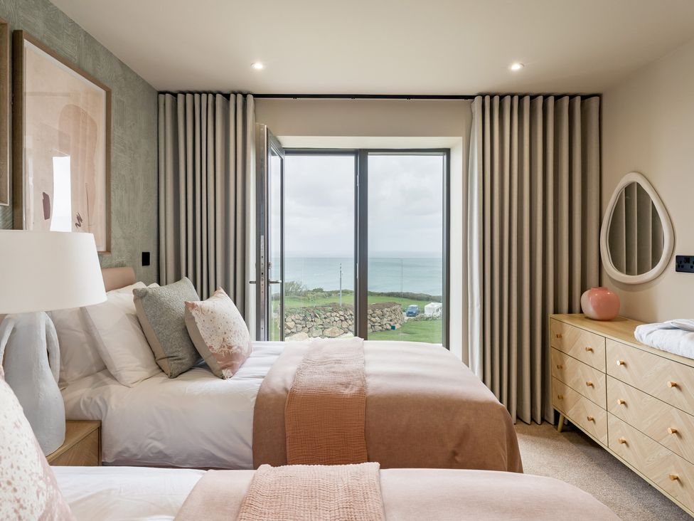 A bedroom with two beds and a view of the sea at tbc in St. Ives