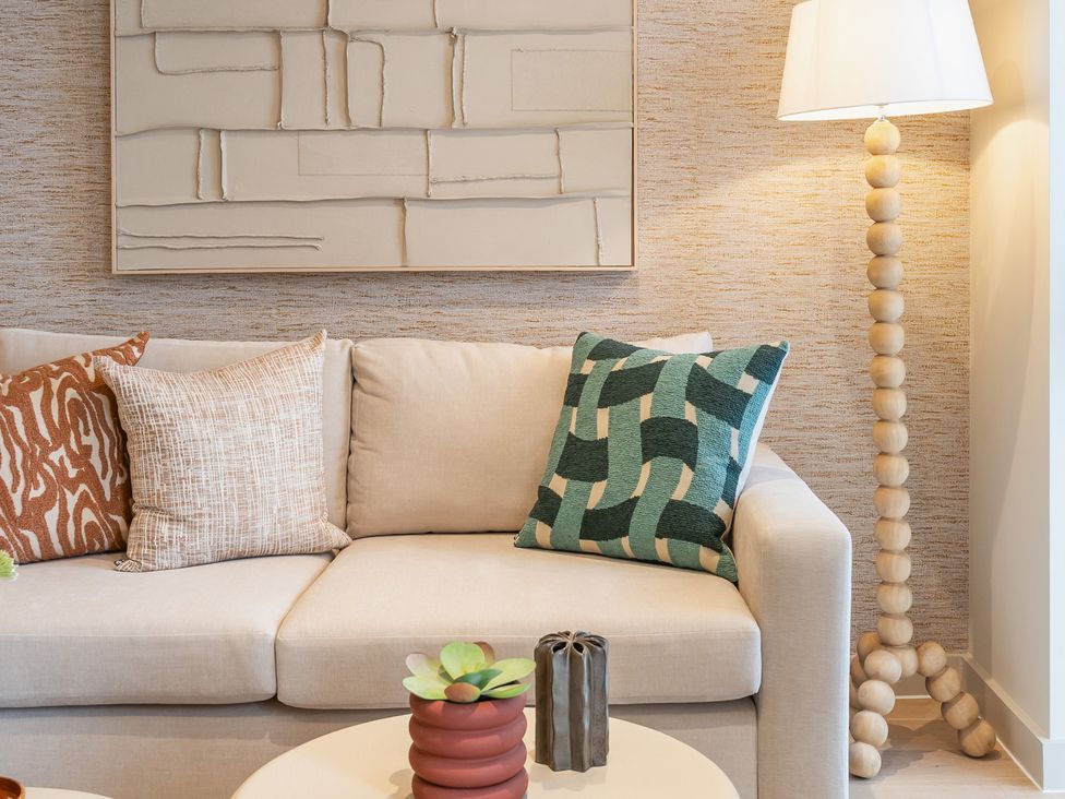 A living room with a sofa and lamp at Hidden 19- Coastal Hot Tub St Ives