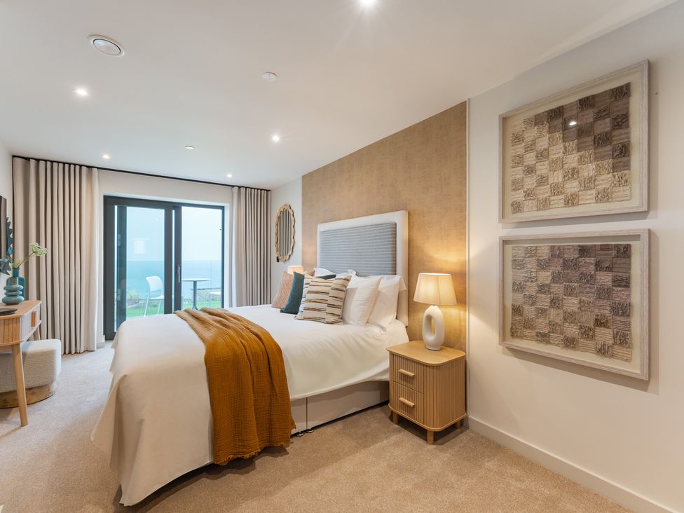 A bedroom with a bed and a view at Hidden 19- Coastal Hot Tub St Ives