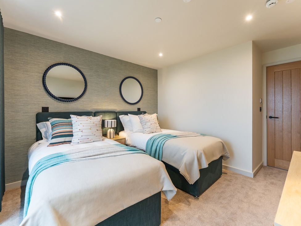 A bedroom with twin beds and mirrors at Hidden 19- Coastal Hot Tub in St Ives